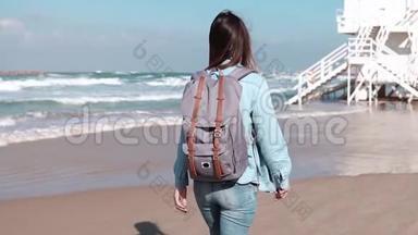 <strong>带</strong>背包的女孩在海岸警卫队哨所散步。 自由。 头发随风<strong>飘动</strong>。 女人在海滩上游荡。 慢动作。
